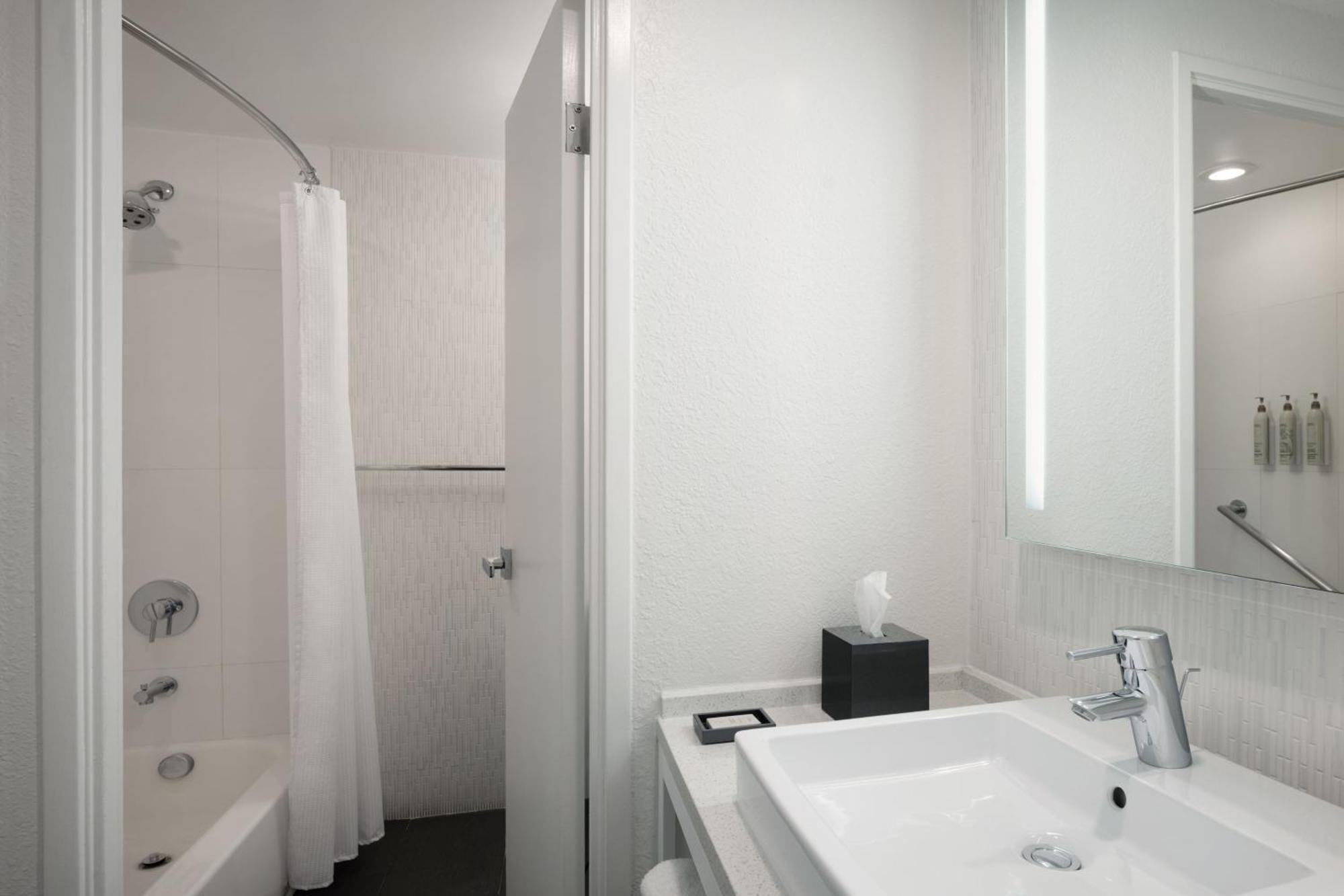 Quarto com cama king-size, vista da piscina, banheira e varanda - Acessível para hóspedes com mobilidade reduzida